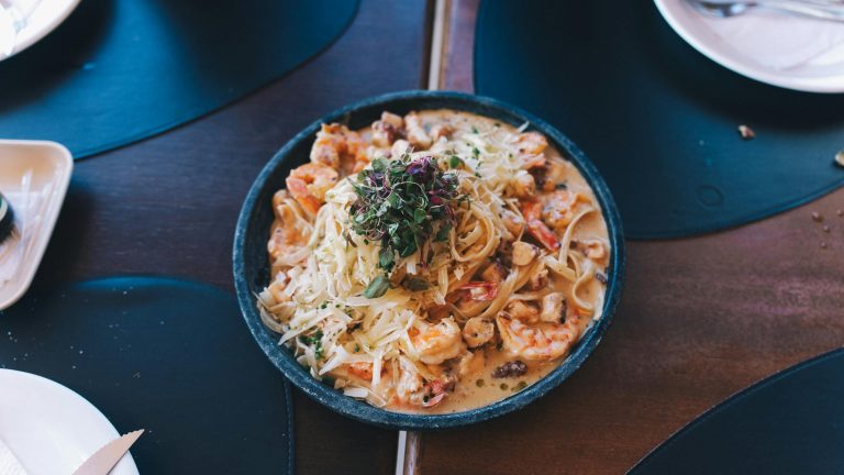 A close-up of a mouthwatering seafood pasta dish with shrimps, garnished elegantly.