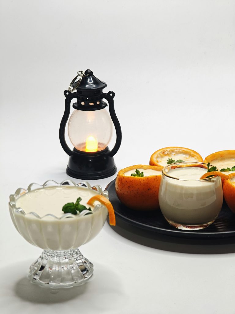 Elegant orange cream desserts paired with a vintage lantern on a white background.